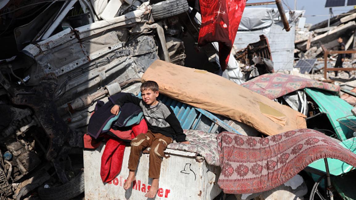 طفل من غزة يجلس فوق ركام منزله