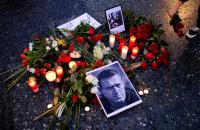 زهور بجوار صور زعيم المعارضة الروسية أليكسي نافالني في برشلونة الإسبانية (رويترز)