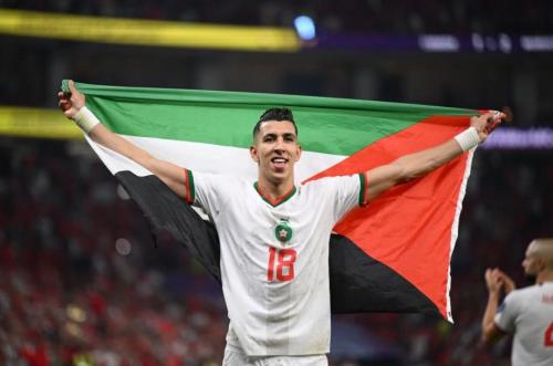 اللاعب المغربي جواد الياميق يرفع علم فلسطين خلال احتفاله بالتأهل