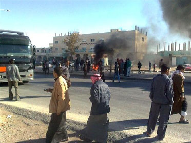 محتجون يغلقون الطريق الملوكي بالحجارة والمركبات