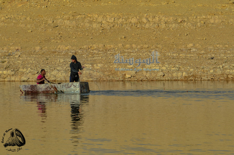 صيادا اسماك في سد الكفرين بقارب صنع محلي